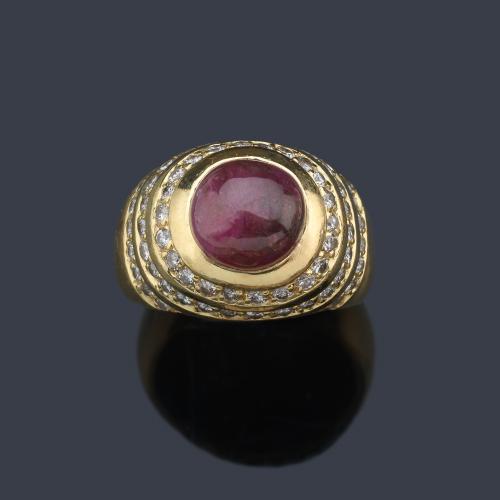  Anillo bombé con rubí cabujón y orlas de bandas de brillantes.