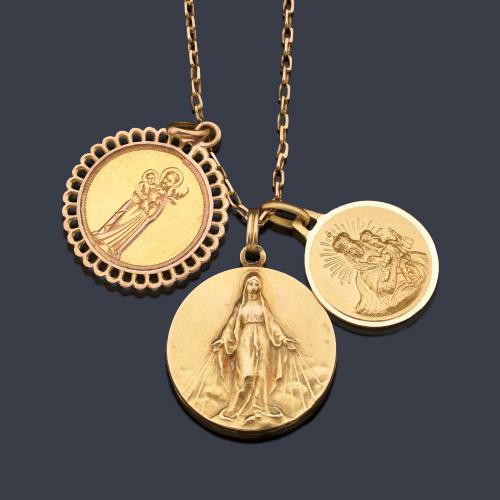  Lote compuesto de tres medallas religiosas y cadena de eslabón fino de oro amarillo de 18K.