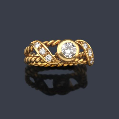  Anillo con dos brazos tipo cordoncillo con brillante en el centro de aprox. 0,30 ct engastado en chatón y dos bandas con tres brillantes cada una.