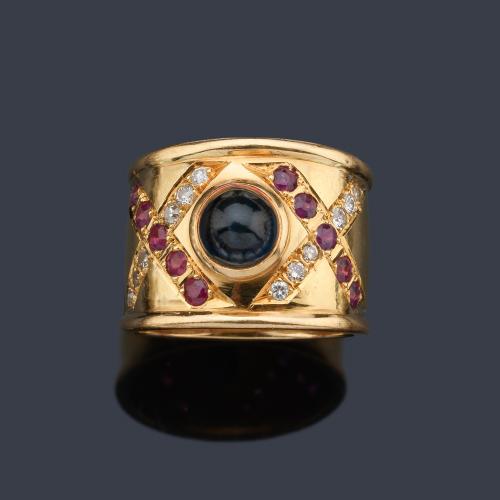  Anillo ancho con frente de zafiro cabujón y dos aspas de brillantes y rubíes.