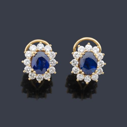  Pendientes con pareja de zafiros talla oval de aprox. 3,69 ct con orla de brillantes de aprox. 1,70 ct en total. Dictamen Gemológico IGE.