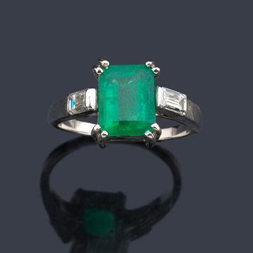  Anillo con esmeralda central de aprox. 2,50 ct con un diamante talla baguette en ambos lados.