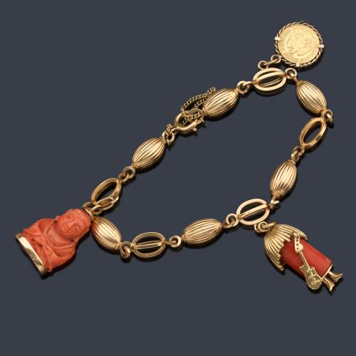  Pulsera en oro amarillo de 18 K con eslabones calados y gallonados, dos colgantes de coral y moneda de dos pesos mexicanos en oro de 22 K.