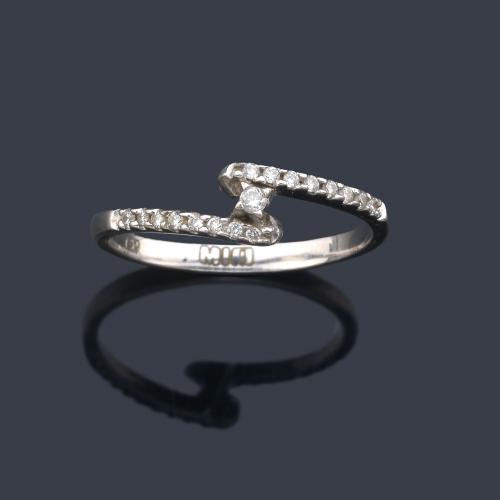  Anillo con dos brazos contrapeados con brillantitos en montura de oro blanco de 18K.