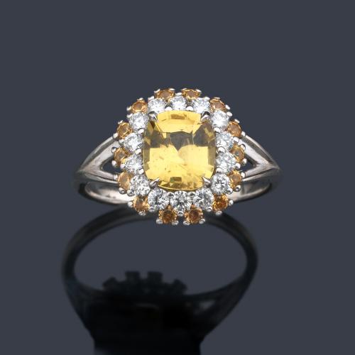  Anillo con zafiro amarillo talla oval de aprox. 21,58 ct con doble orla de brillantes de aprox. 0,40 ct y zafiros amarillos y orla de zafiros amarillo de 0,33 ct total.