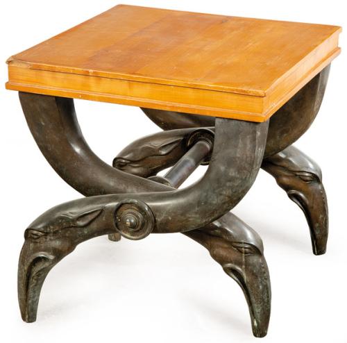  Silla Curul o sella curulis. Base de tres soportes arqueados en bronce patinado que se cruzan en el centro, reinterpretando en clave escultórica contemporánea la tipología de los escabeles curules de tradición clásica, con remates zoomorfos en las patas.