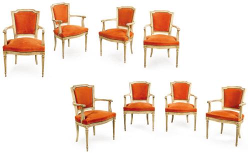  Conjunto 12 butacas estilo Luis XVI, en madera pintada en blanco, con respaldo recto ligeramente trapezoidal enmarcado por molduras talladas, perfil superior suavemente curvado y brazos escuadrados, rematados en roleos tallados. El asiento, bajo y generos