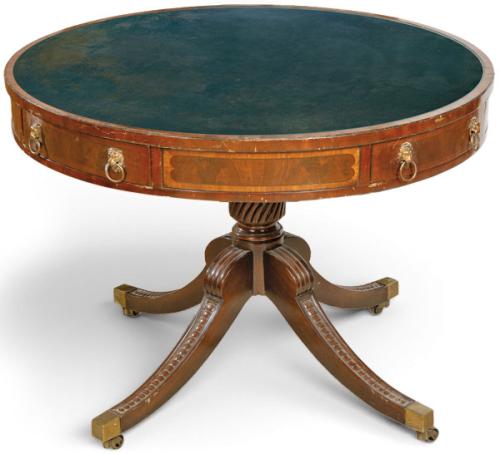  Mesa de biblioteca Regencia, con tapa cilíndrica tipo "tambor" y cuero verde. Sobre pedestal torneado y patas talladas y acanaladas acabadas en bronces.