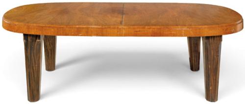  Mesa de comedor Art Decó, con tapa oval chapada en raíz de nogal con vetas simétricas; faldón continuo de nogal sobre cuatro patas periféricas.