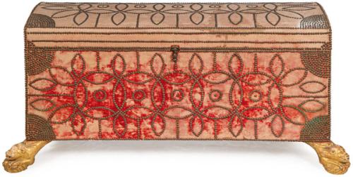 Arca ensayalada y tachonada, rectangular, con tapa ligeramente curva, con decoración de tachuelas de latón. Sobre patas en forma de leones en madera tallada y dorada.