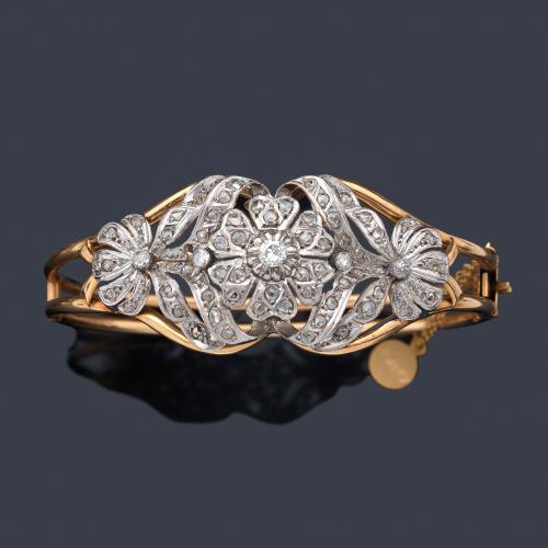  Pulsera rígida con diseño frontal floral con diamantes talla brillante y rosa, realizado en montura de 18K y vista en platino.
