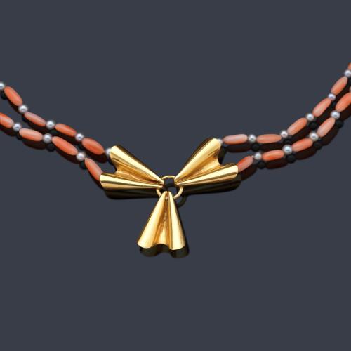  Collar corto con dos hilos de coral con diseño en barrilete intercalado con perlita gris, rematado con diseño de lazada en oro amarillo de 18K.