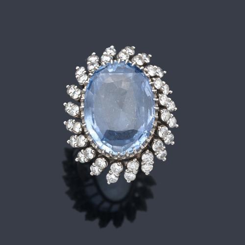  Anillo con gran zafiro talla oval de aprox. 22,28 ct y orla de brillantes de aprox. 2,00 ct en total. Años '60.