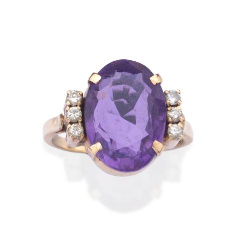  Anillo con amatista talla oval de aprox. 6,00 ct con banda de brillantitos en ambos lados.