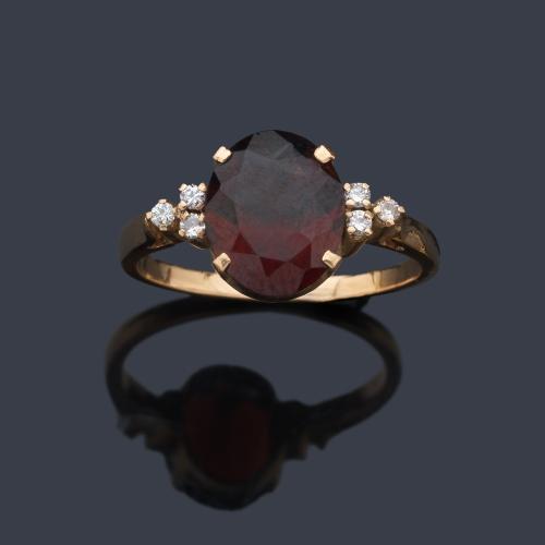  Anillo con granate almandino talla oval de aprox. 2,80 ct con brillantitos en ambos lados.