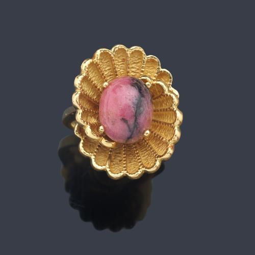  Anillo años '70 con cuenta esférica de rodolita sobre dos motivos curvados realizados en montura de oro amarillo de 18K.