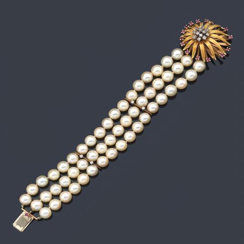  Pulsera con tres hilos de perlas de aprox. 8,00 mm con cierre floral realizado en oro amarillo de 18K decorado con brillantes y rubíes.