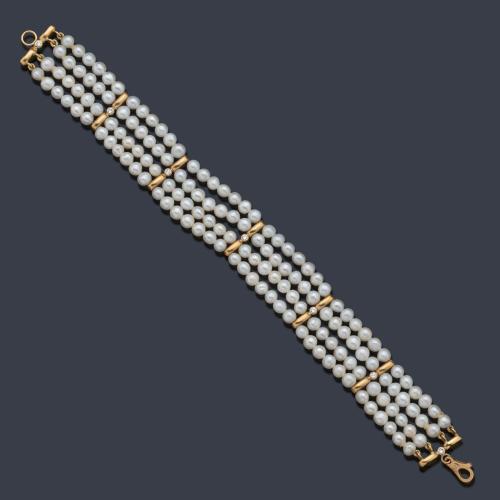  Pulsera con cuatro bandas de perlitas intercalado con pasadores en oro amarillo de 18K. Años '70.