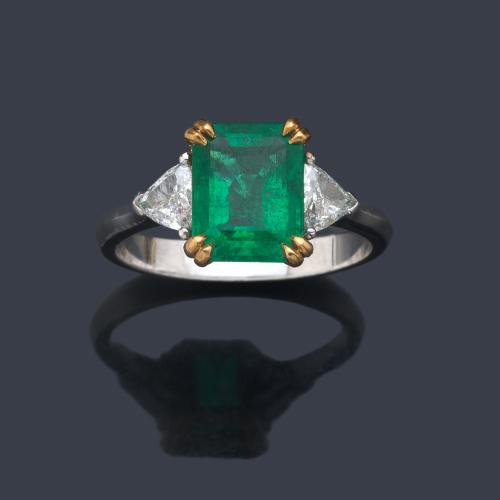  Anillo con esmeralda central de aprox. 2,90 ct con dos diamantes talla triángulo de aprox. 0,40 ct en total.