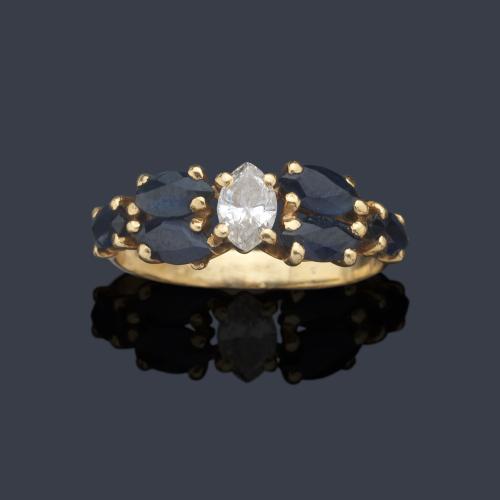  Anillo con diamante talla marquís y zafiros en ambos lados talla marquís, realizado en montura de oro amarillo de 18K.