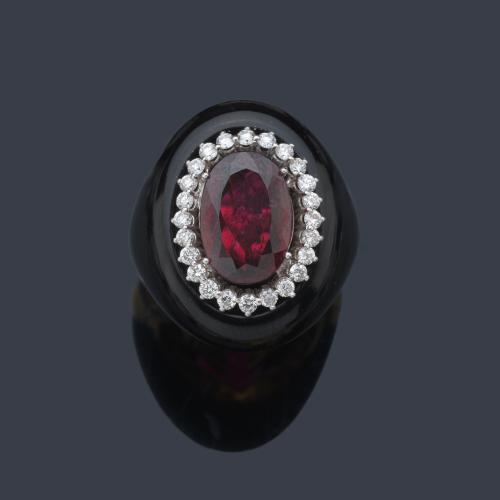  Anillo con turmalina rubelita talla oval de aprox. 4,86 ct con orla de brillantes de aprox. 0,62 ct en total, en montura de piedra dura y oro amarillo de 18K.