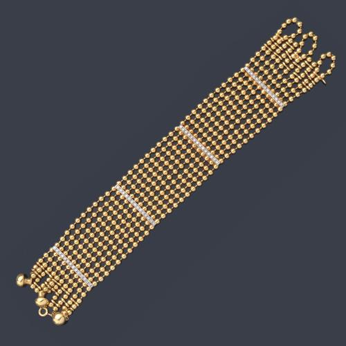 Pulsera con diez bandas de bolitas realizadas en oro amarillo de 18K y barritas con brillantes.