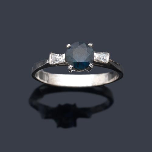  Anillo con zafiro talla oval de aprox. 0,50 ct con dos diamantes talla trapecio.