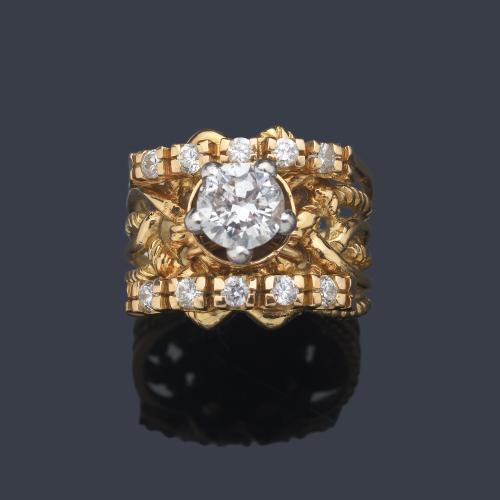  Anillo con brillante central de aprox. 1,10 ct con dos bandas de diamantes sobre montura calada de oro amarillo de 18K.