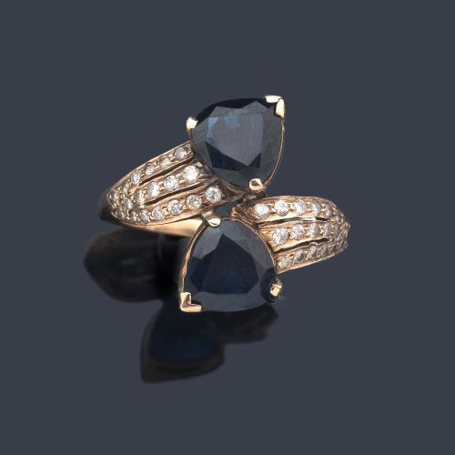 Anillo 'tú y yo' con pareja de zafiros talla fantasía con tres bandas de brillantitos en ambos lados.