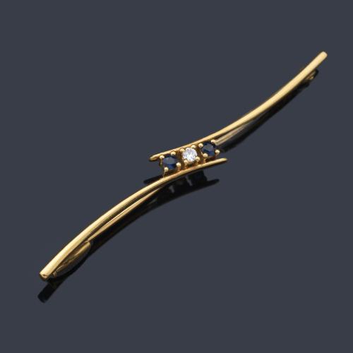  Broche - alfiler con dos zafiros y brillante central sobre montura de oro amarillo de 18K.
