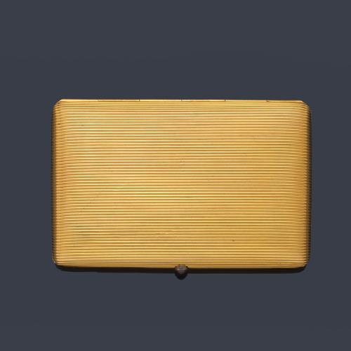  Pitillera realizada en oro amarillo de 18K con decoración rallada y apertura con motivo de rubí talla cabujón.