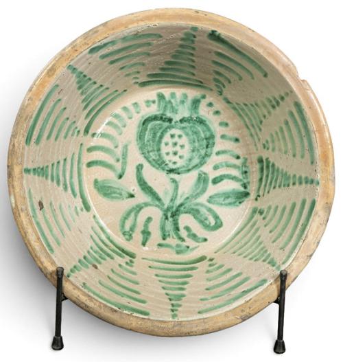  Lebrillo en cerámica esmaltada de Fajalauza, de fondo claro, con decoración en verde de granada estilizada, tallo y hojas en el asiento. Cenefa de grupos de trazos curvos paralelos