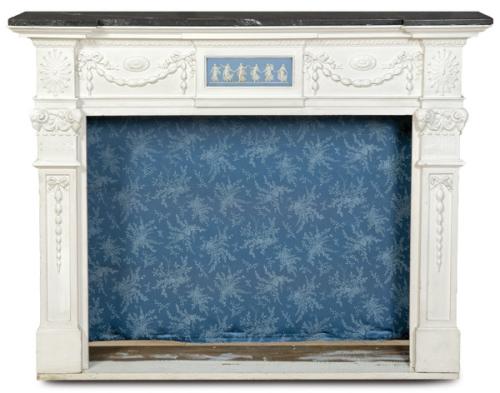  Chimenea George III, realizada en madera tallada, moldurada y pintada de blanco, con repisa de mármol negro y placa central de jasperware azul con relieve blanco, manufactura Josiah Wedgwood & Sons.