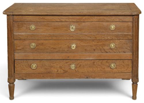  Arca Luis XVI en madera de roble macizo, de estructura rectangular, con tapa abatible y tres registros simulados, con tiradores y escudos de cerradura en latón, flanqueados por montantes acanalados. 